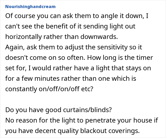 Neighbour-installed actual sun motion sensor light on exterior wall illuminating outdoor area at night.