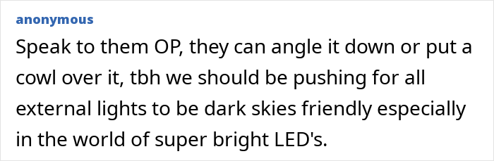 Neighbour-installed actual sun style solar light mounted on a white brick wall illuminating outdoor space at night.